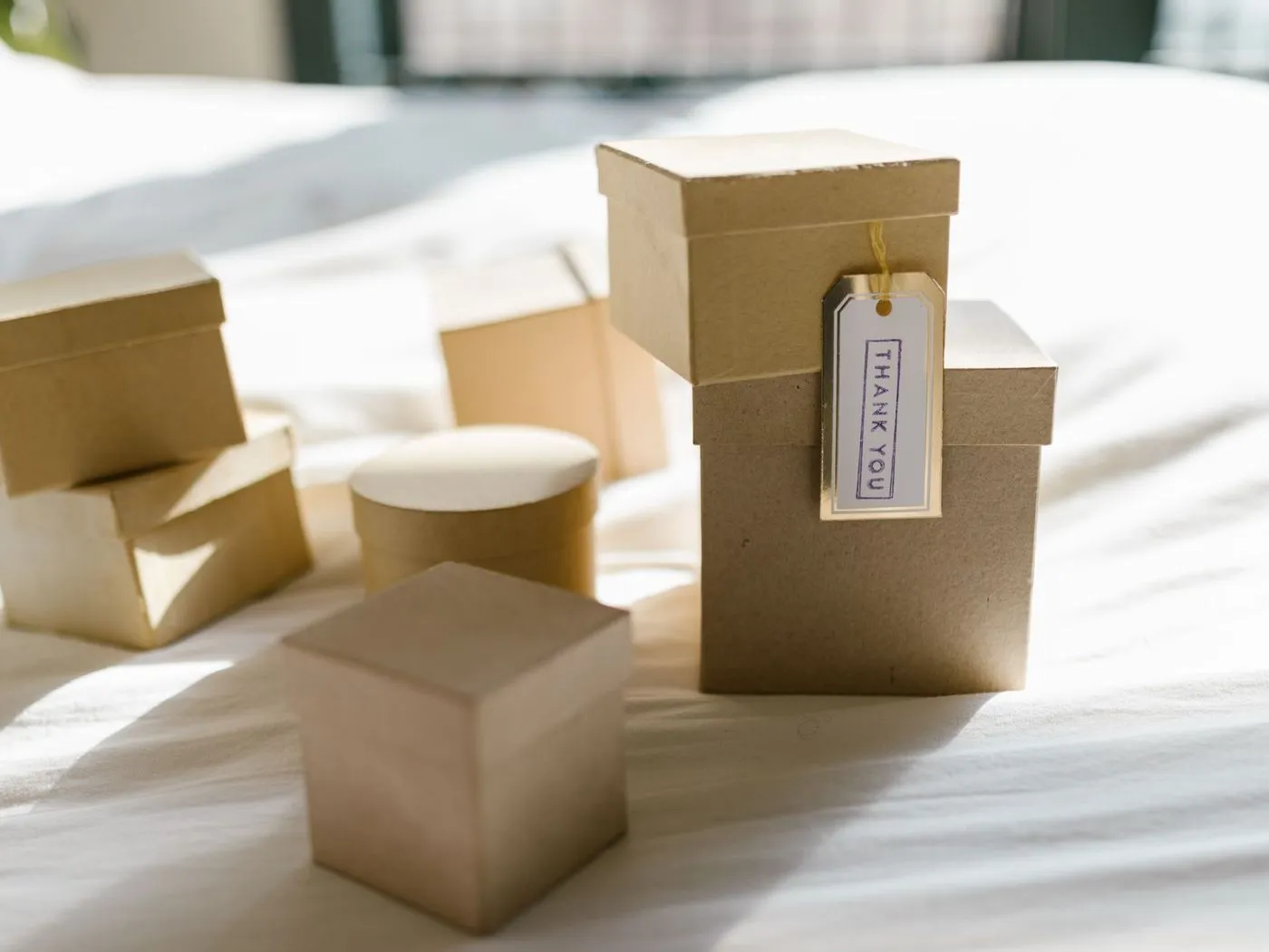 Kraft gift boxes ready to ship, one with a handwritten thank-you tag